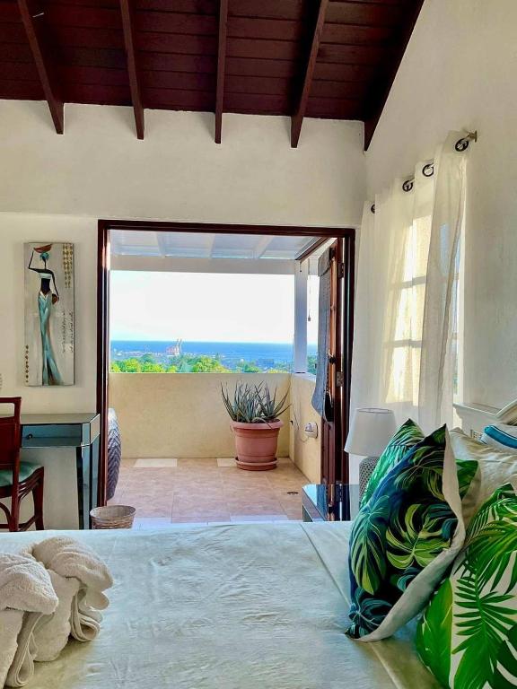 a bedroom with a bed and a large window at Harbour View - by ZenBreak in Saint Michael