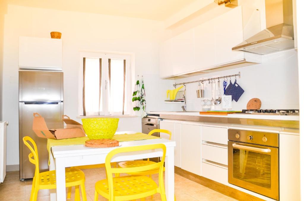 a kitchen with a table and yellow chairs in it at CoreHome in Albano Laziale