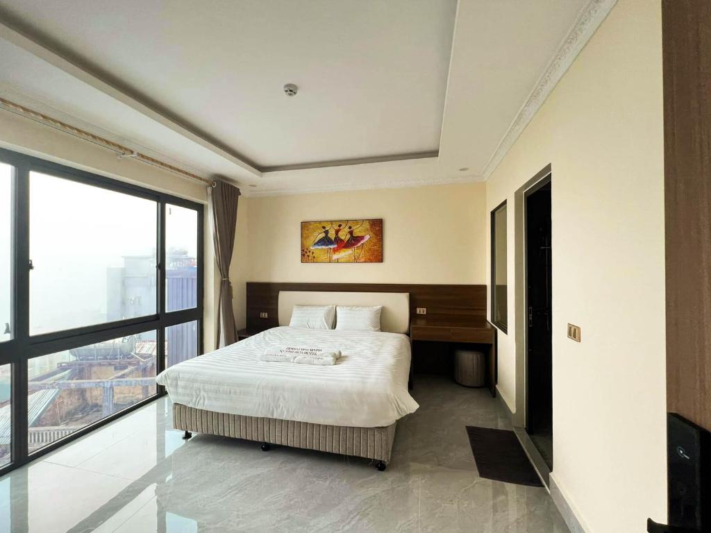 una camera da letto con un letto e una grande finestra di TGlobal Quynh Hoa Tam Dao a Tam Ðảo
