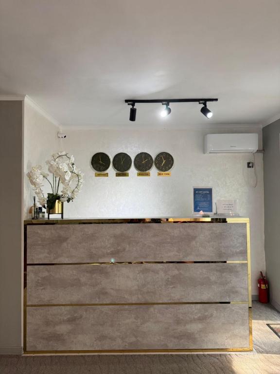a dresser in a room with three plates on the wall at BT City Hotel in Gornyy Gigant