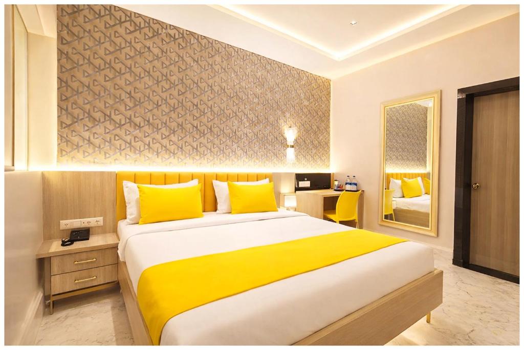 ein Schlafzimmer mit einem großen Bett mit gelben Kissen in der Unterkunft Hotel S-Swastik Residency Near Jagannath Temple and Sea Beach - Fully Air Conditioning Rooms - Free Wifi and Room Service - Best Premium Hotel In Puri in Puri