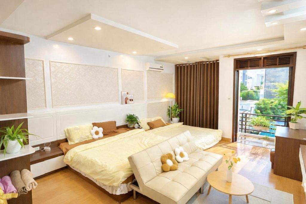 een slaapkamer met een groot bed en een bank bij Uni Homestay 2 in Hai Phong