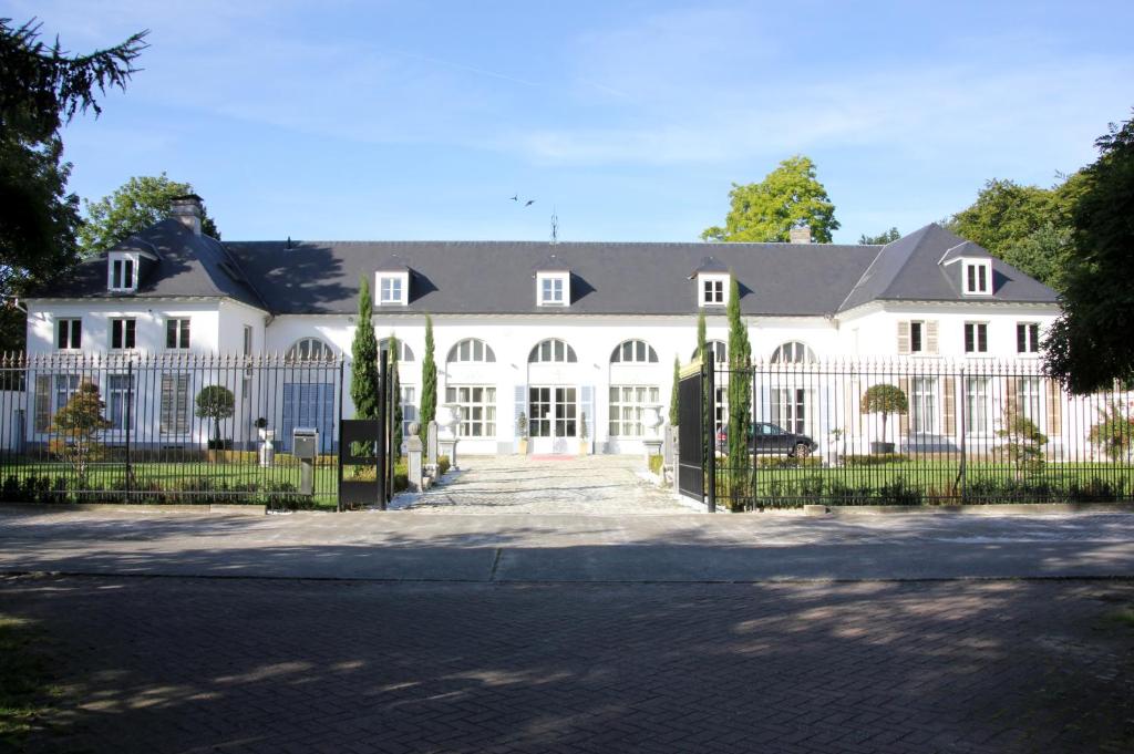 a large white house with a white fence at Luxury Suites Arendshof in Antwerp