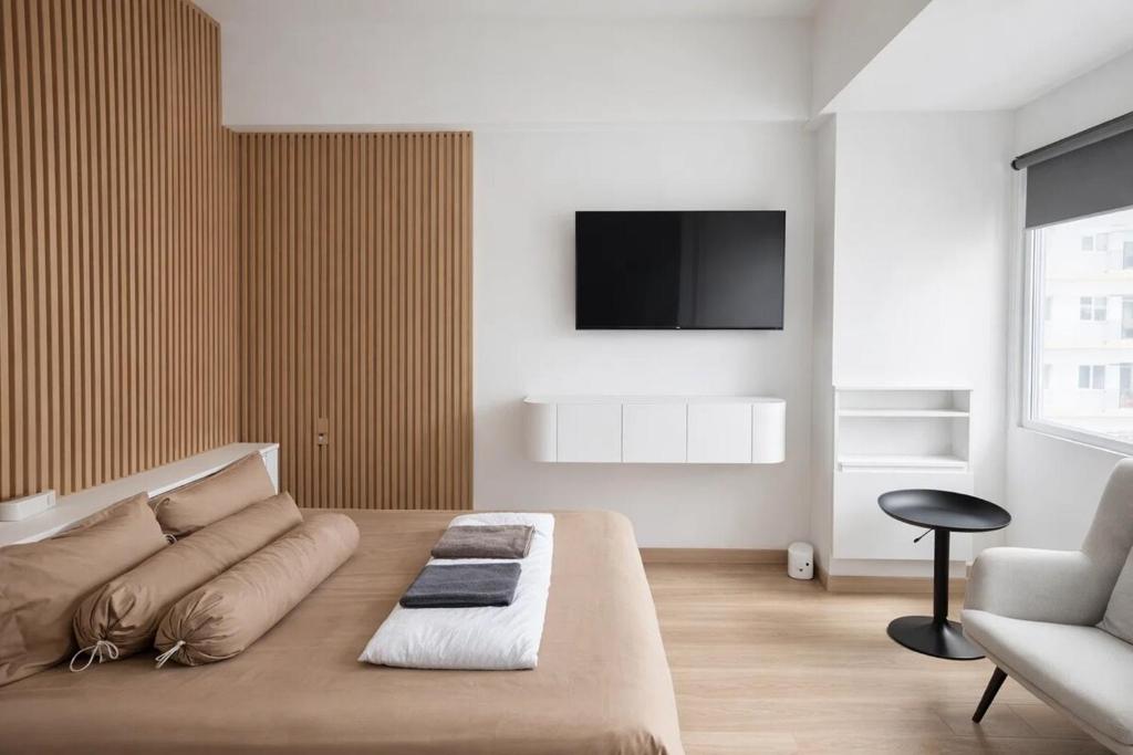 a living room with a couch and a tv on the wall at Ignis by KolivHub I Studio I Sentul in Kedungmanggu