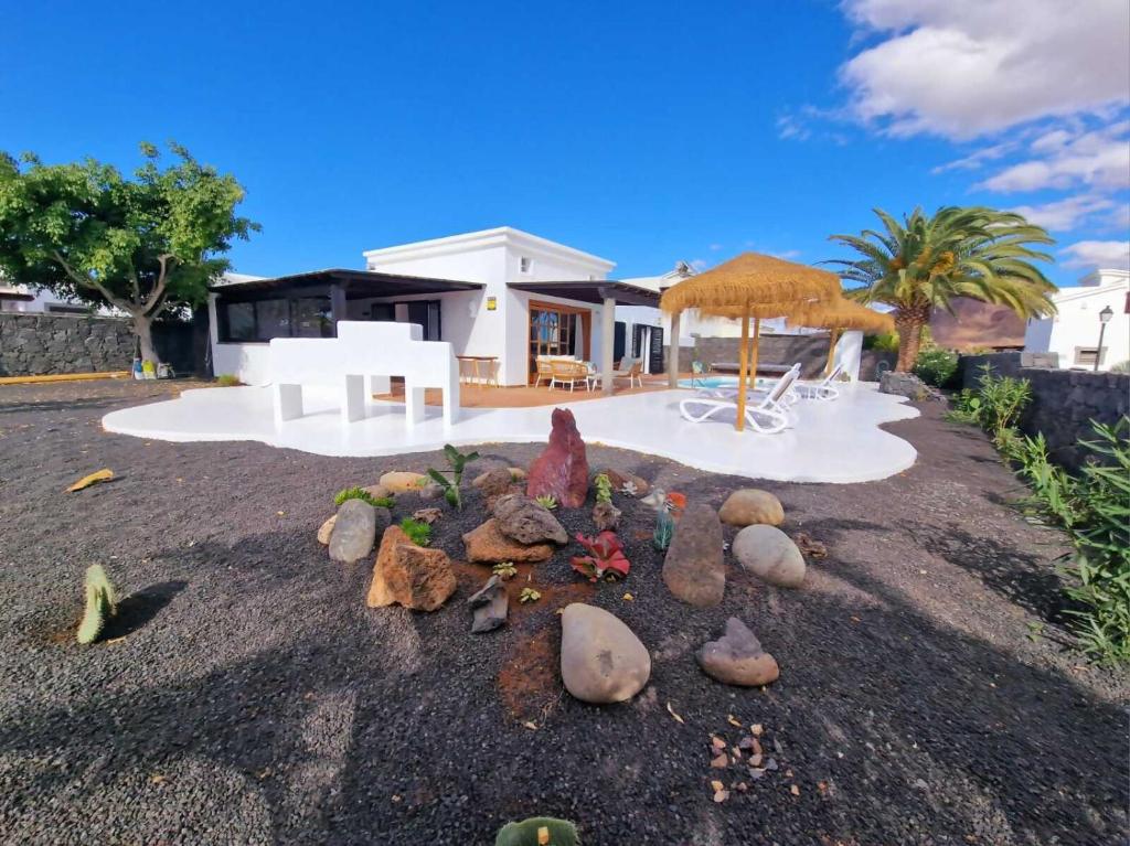 a bunch of rocks on the ground in front of a house at Costa Christina con piscina climatiza in Yaiza