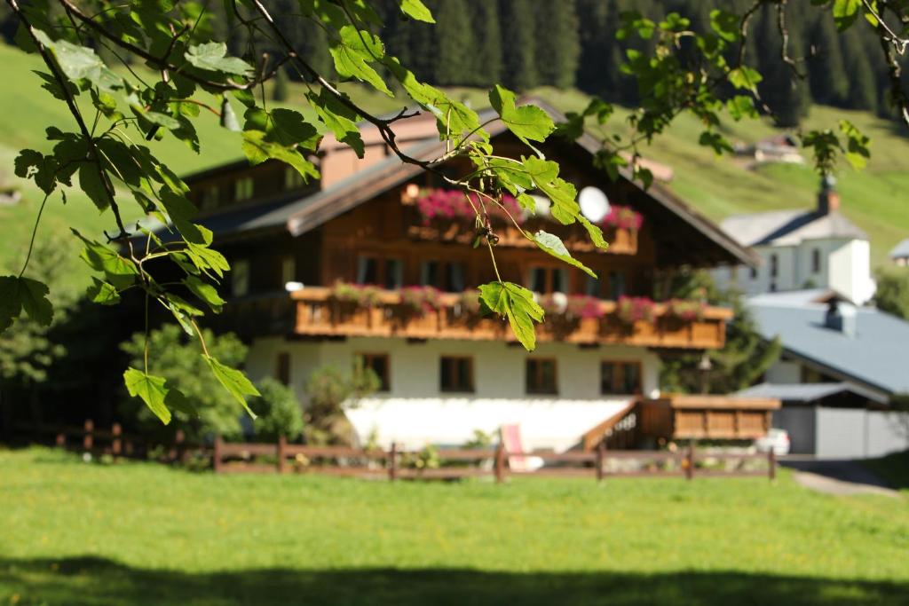 a large house with flowers on the balcony of it at Haus Derra in Mittelberg