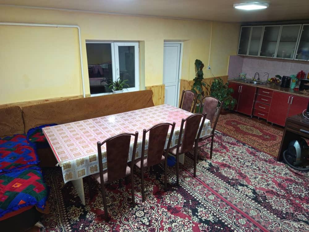 ein Esszimmer mit Tisch und Stühlen in einer Küche in der Unterkunft Гостевой дом Куттуу Кол in Kichi-Jargylchak