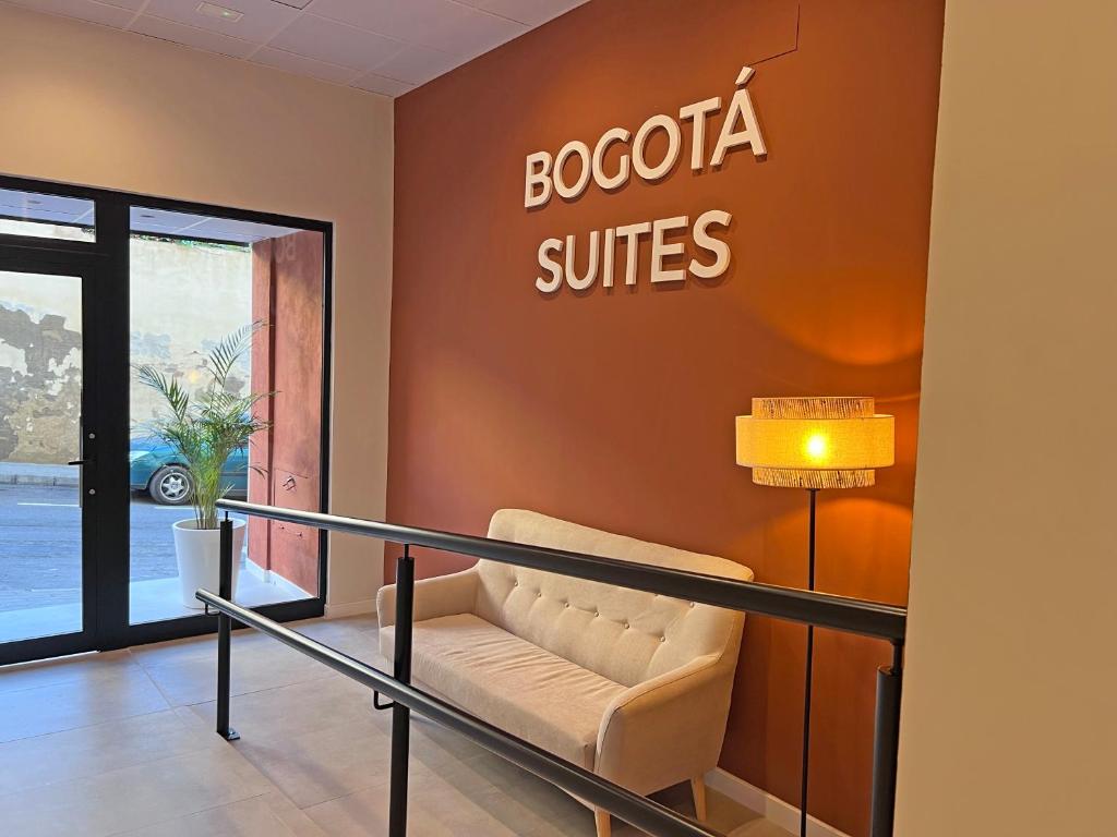 a waiting room with a couch and a sign on a wall at NUEVO -Bogotá Suites- Apartamentos con cocina, AC, 15min del centro a pie in Alicante
