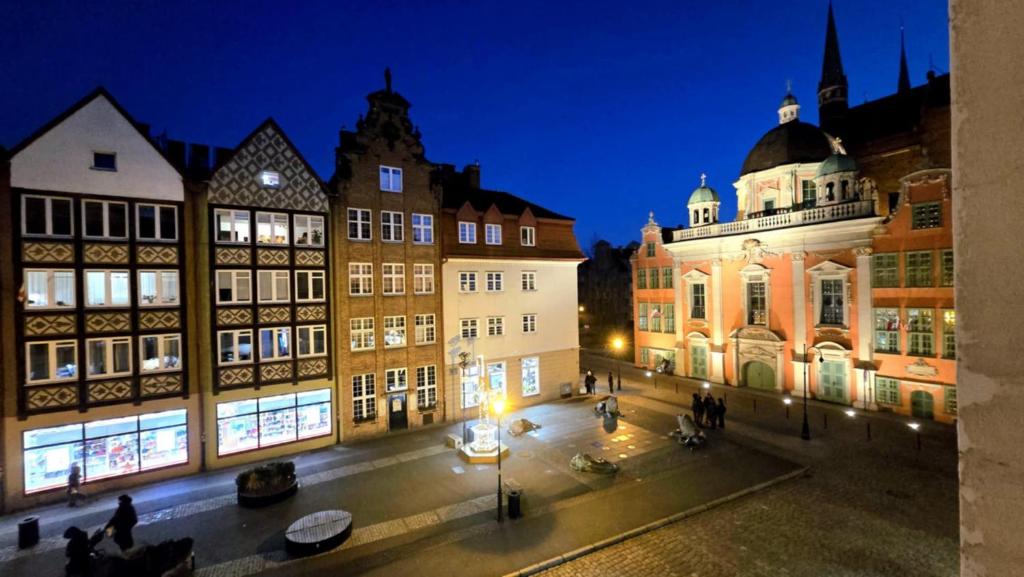 a group of buildings in a city at night at 4 Lions Guest House in Gdańsk