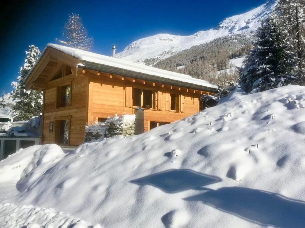 una casa coperta da neve con tetto ricoperto di neve di Vieux Zinal a Zinal