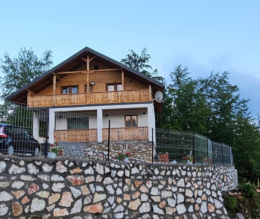 een huis bovenop een stenen muur bij Casa din fagi in Munună