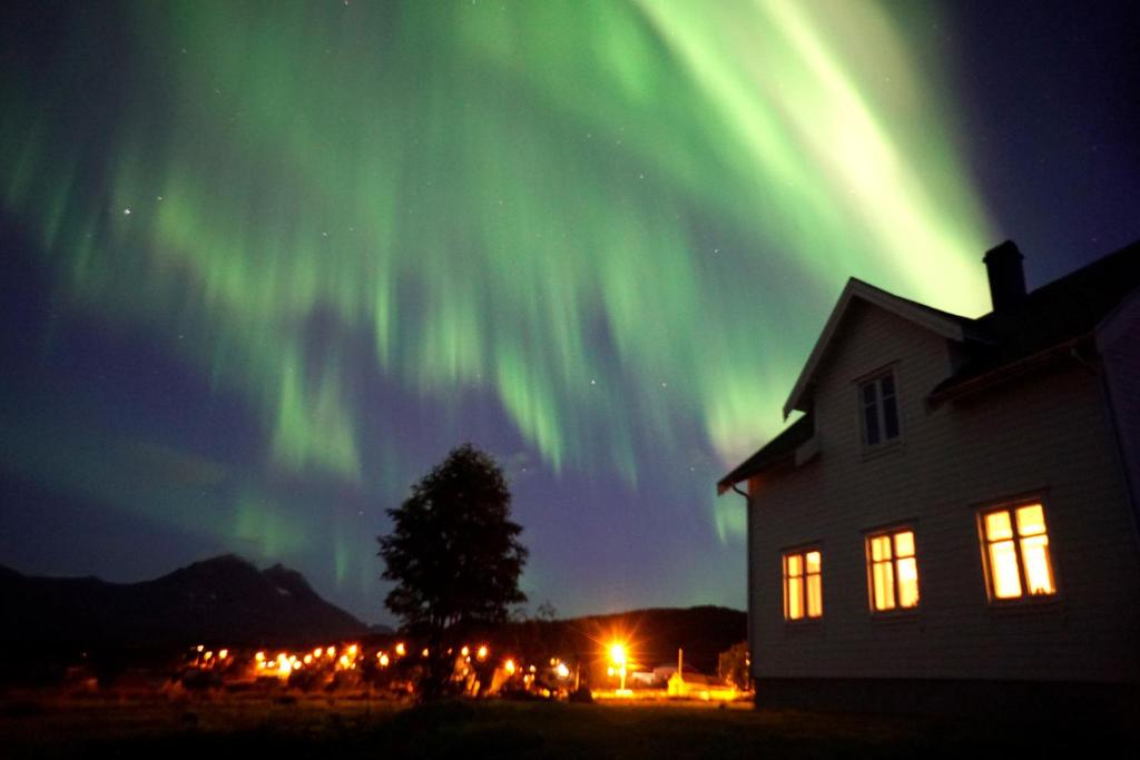 une image de l'aurore boralis sur une maison dans l'établissement Larseng Kystferie, à Larseng