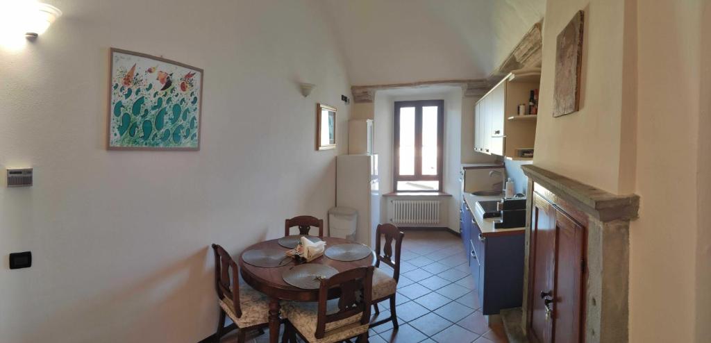 een keuken en eetkamer met een tafel en stoelen bij Dimora Fenni - Appartamento elegante nel cuore di Monte Isola con Wi-Fi e aria condizionata in Monte Isola