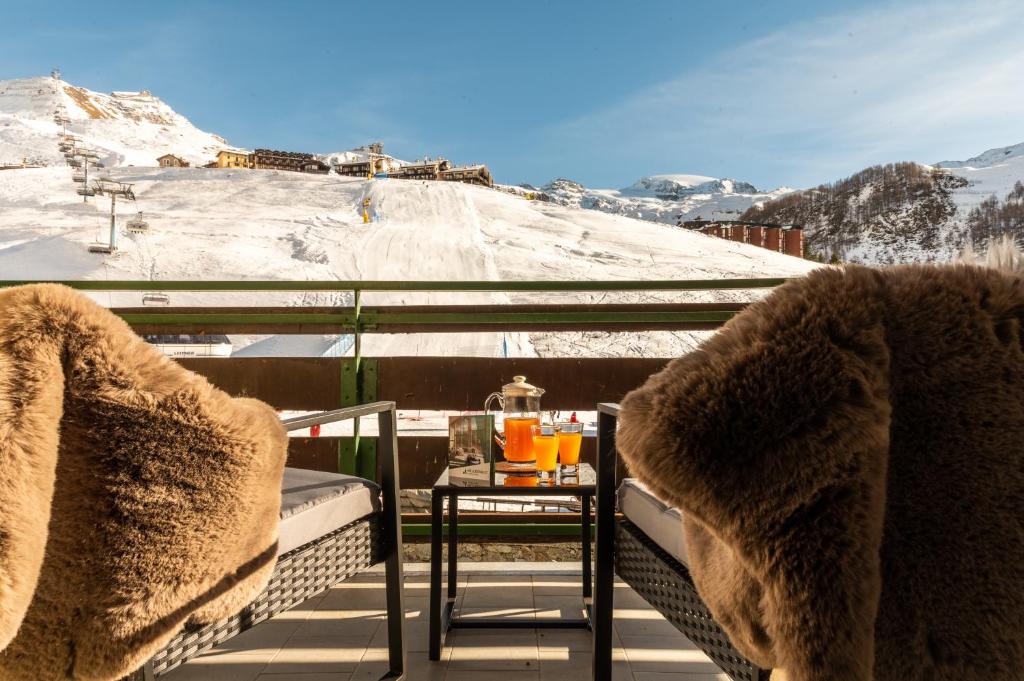 een tafel en stoelen op een balkon met sneeuw bij HelloCHALET TrackSide House - Ski-In Ski-Out Apartment on the Cretaz Slopes in Breuil-Cervinia