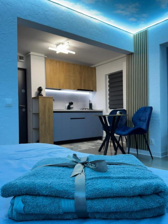 a bedroom with a blue bed and a kitchen at Cloud Express in Petroşani