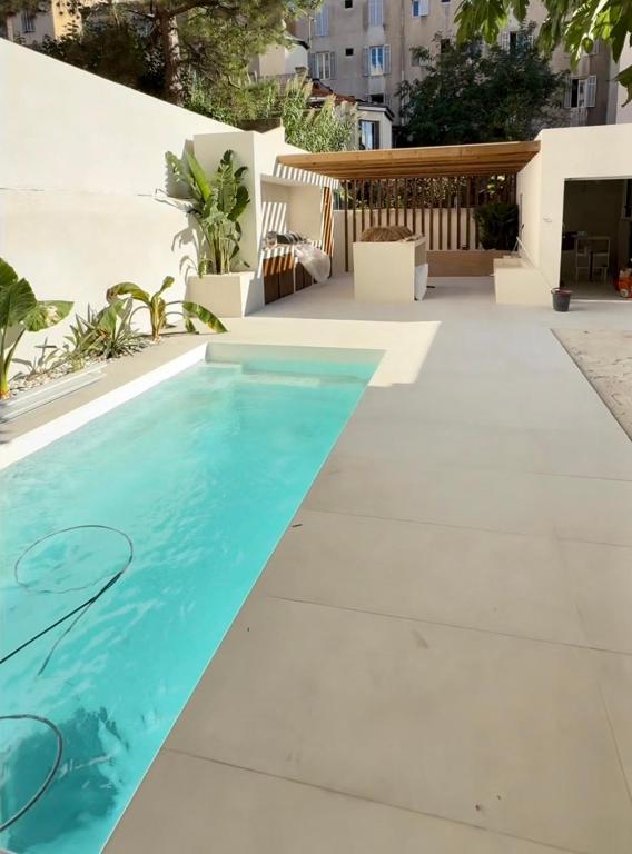 a swimming pool in the middle of a patio at Maison Massilia Duclaux in Marseille