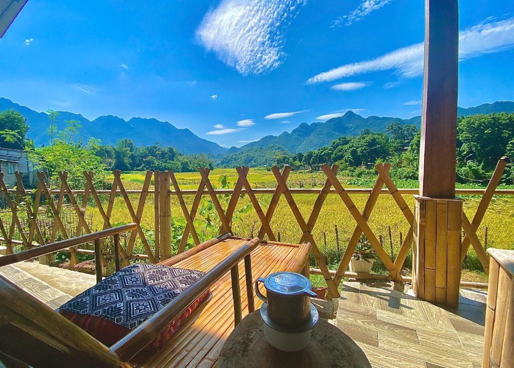a porch with a bench and a view of a vineyard at Meadow Mai Chau Homestay in Mai Chau