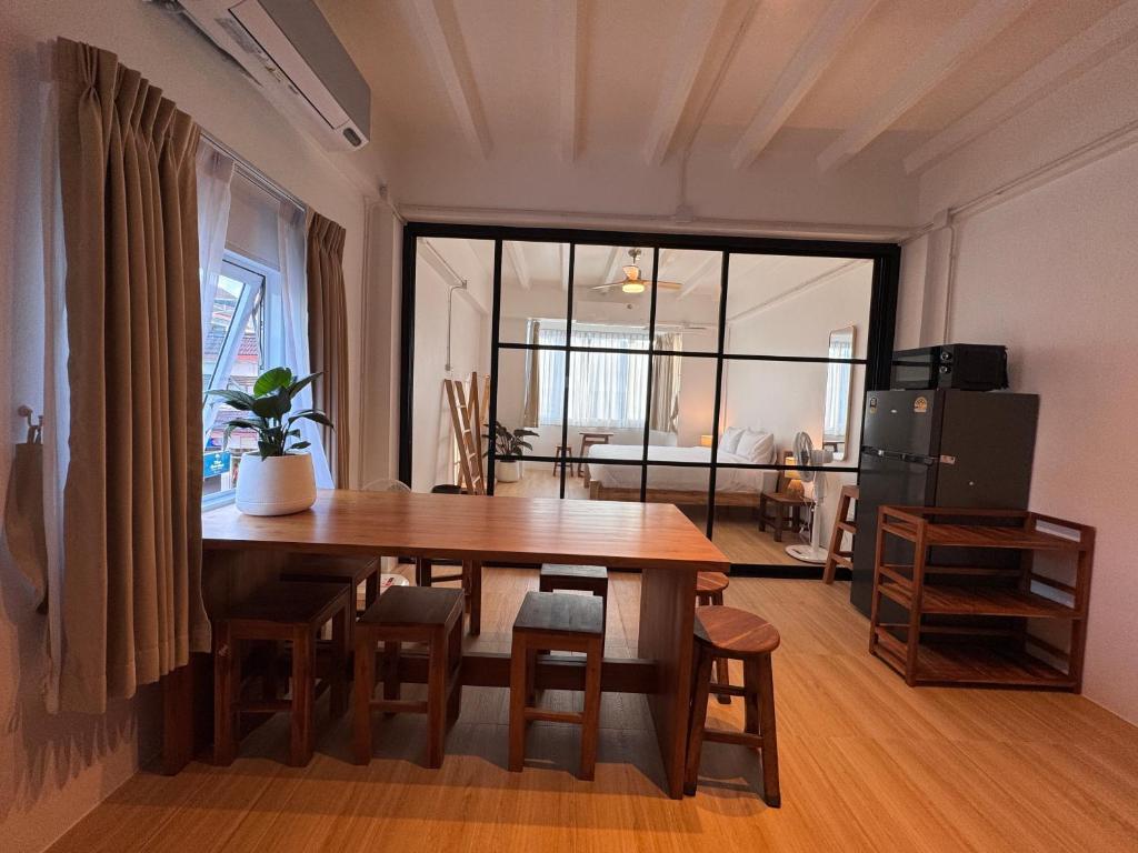 een eetkamer met een tafel en een groot raam bij Cloud House in Chiang Mai