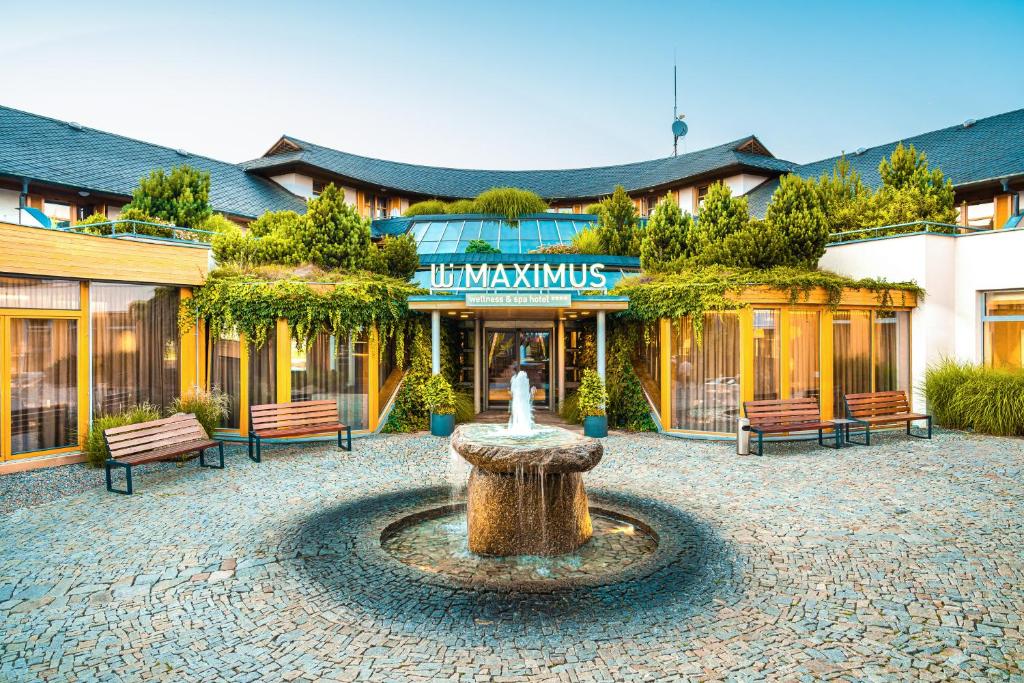 a building with a fountain in the middle of a courtyard at Maximus Resort in Brno