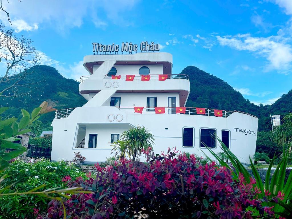 een groot wit schip met bloemen ervoor bij Titanic Mộc Châu in Mộc Châu