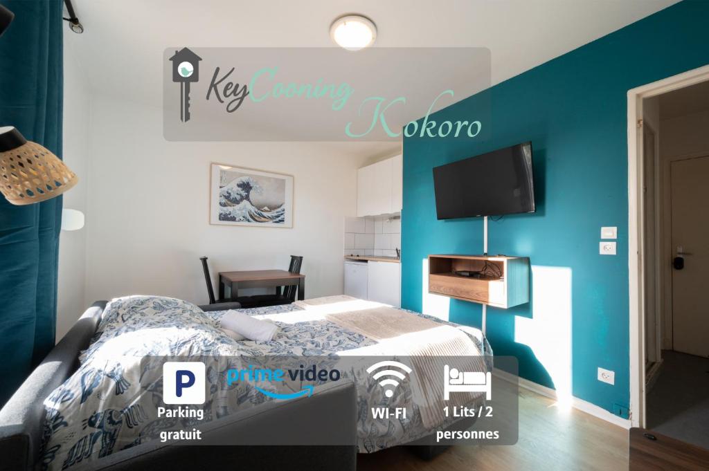 ein Schlafzimmer mit einem Bett und einem Fernseher an der Wand in der Unterkunft Kokoro - Parking in Ramonville-Saint-Agne