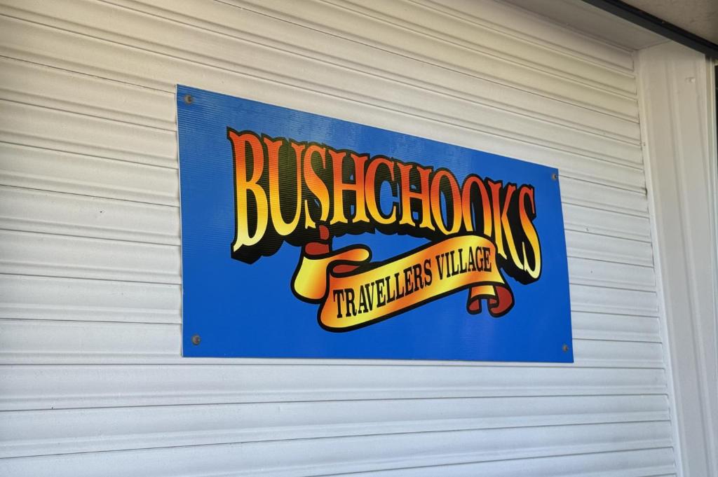 a sign on the side of a garage at Bushchooks Travellers Village in Bororen