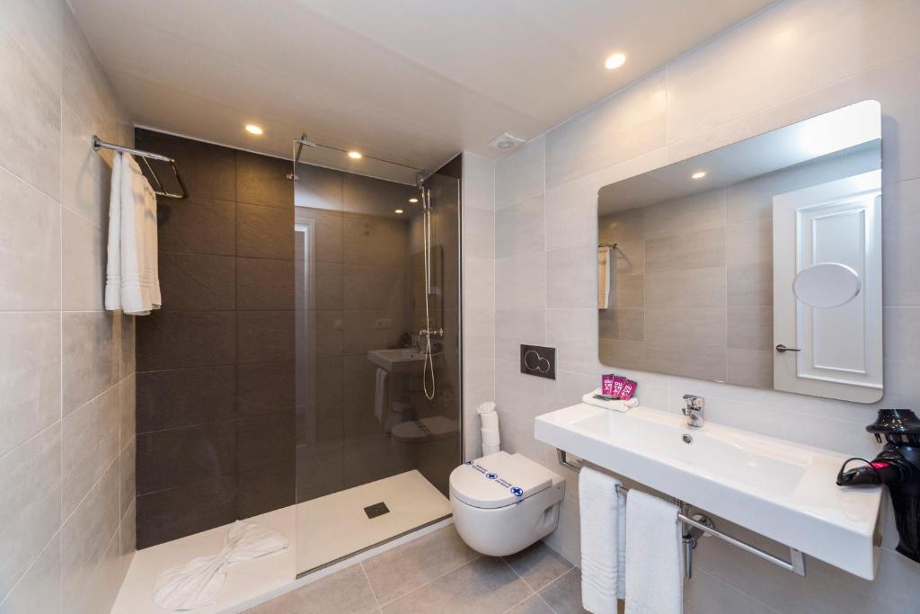 a bathroom with a shower and a sink and a toilet at Comitas Floramar in Cala Galdana