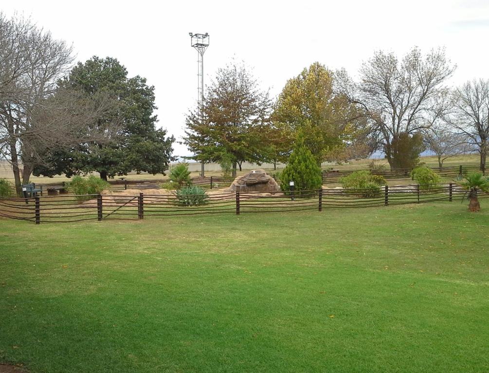 a fence in a field with green grass at Ezulwini Berg Resort in Ethels Drive