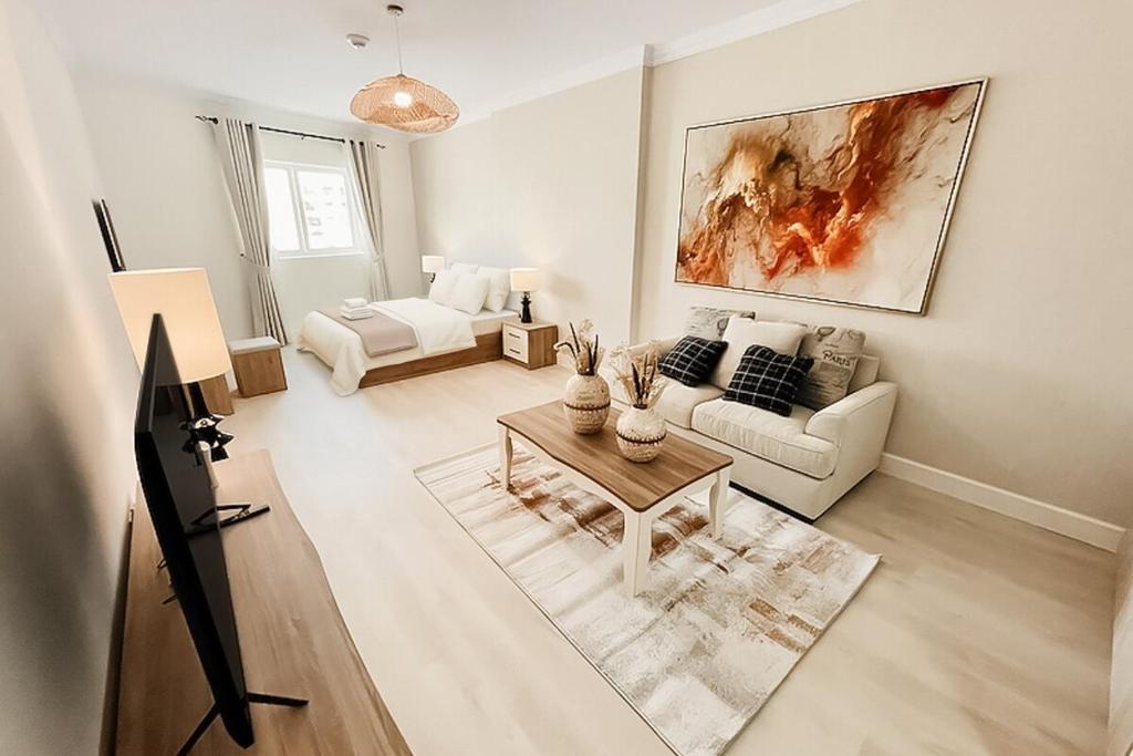 a living room with a couch and a table at Stylish Furnsihed Apartments Opposite Five Hotel In JVC in Dubai
