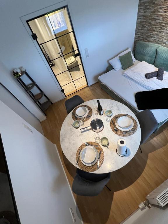 ein Tisch und Stühle in einem kleinen Zimmer mit einem Bett in der Unterkunft Little Rose - modern, central with WiFi & parking in Bad Sobernheim