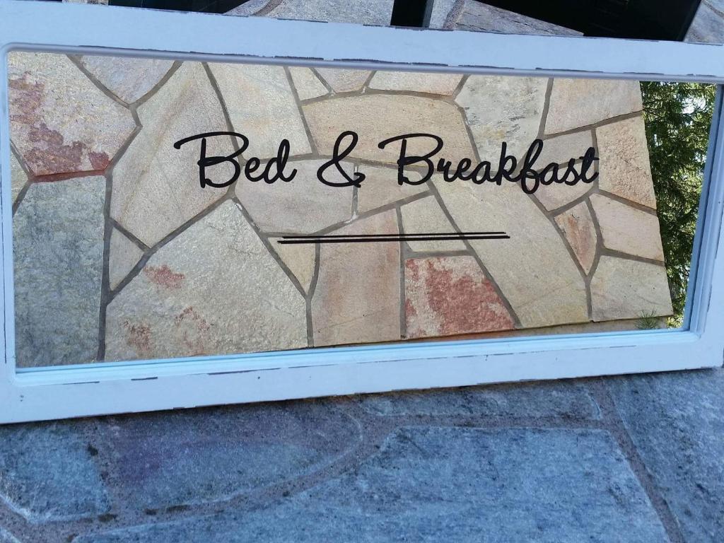 una finestra con un cartello che legge il bed and breakfast di B&B Neulomotie a Orimattila