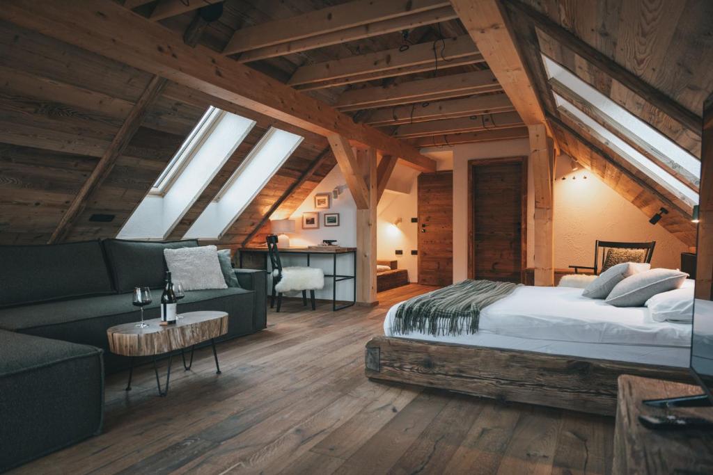 a bedroom with a bed and a couch and a desk at Domačija Majer'ca in Bohinj
