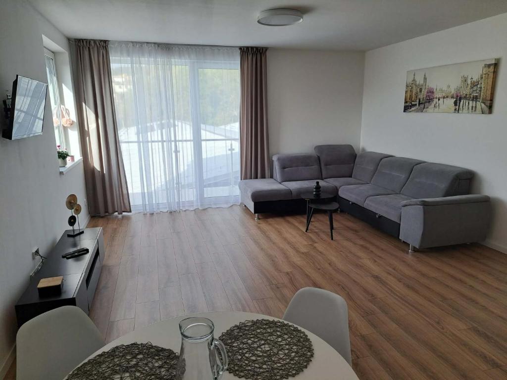 un soggiorno con un divano e un tavolo di Apartmány Karpatia s historickým výkladom a Svidník