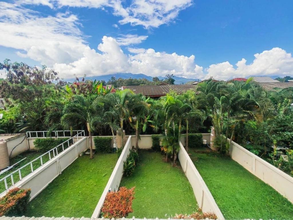 einen Blick vom Balkon eines Hauses mit Palmen in der Unterkunft Donkaew minimalist townhouse in Ban Mae Sa Luang
