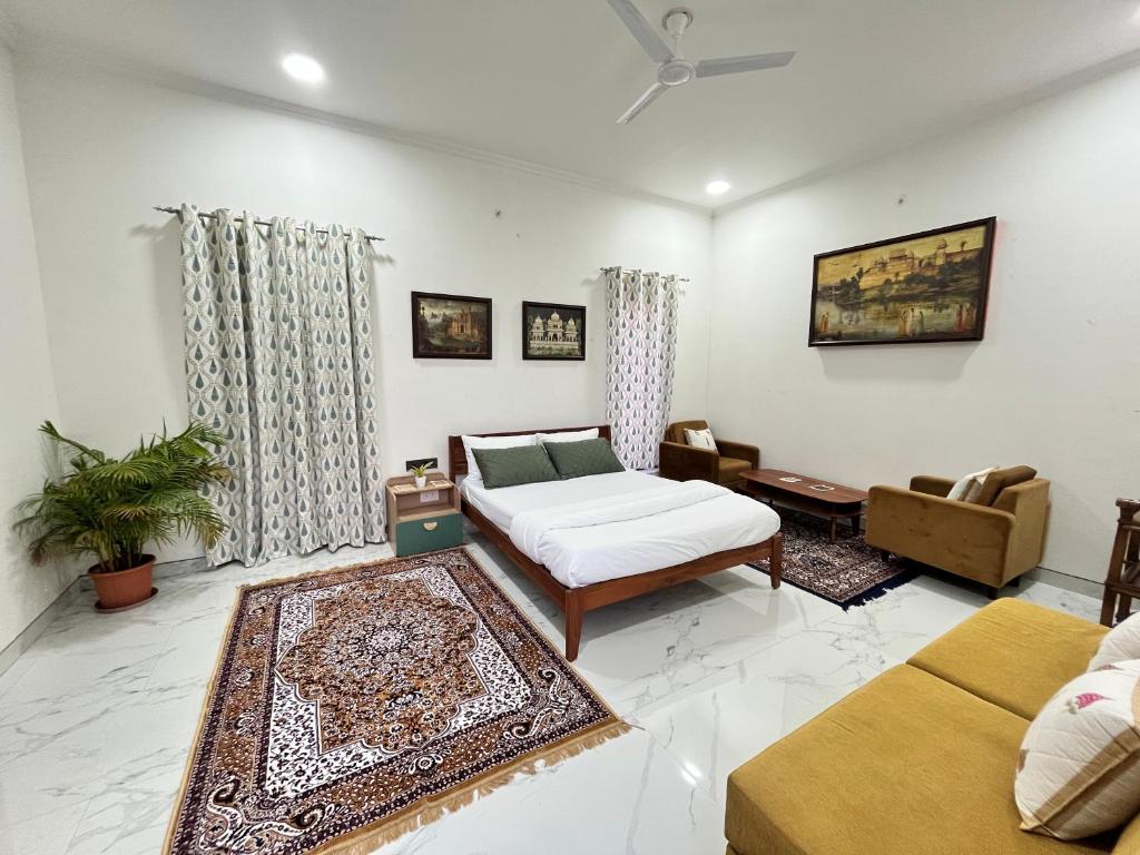 een woonkamer met een bed en een bank bij Flora A rooftop with serenity and peace in Jaipur