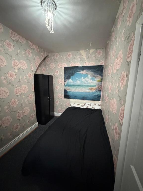 een slaapkamer met een bed en een schilderij aan de muur bij Homey room in Liverpool
