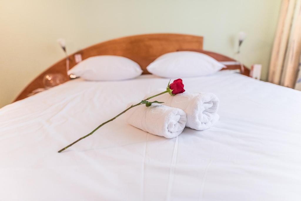 a bed with towels and a rose on it at Park Hotel in Bihać