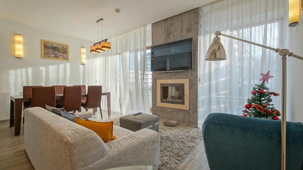 a living room with a christmas tree on the wall at Chambres Mountain in Poiana Brasov