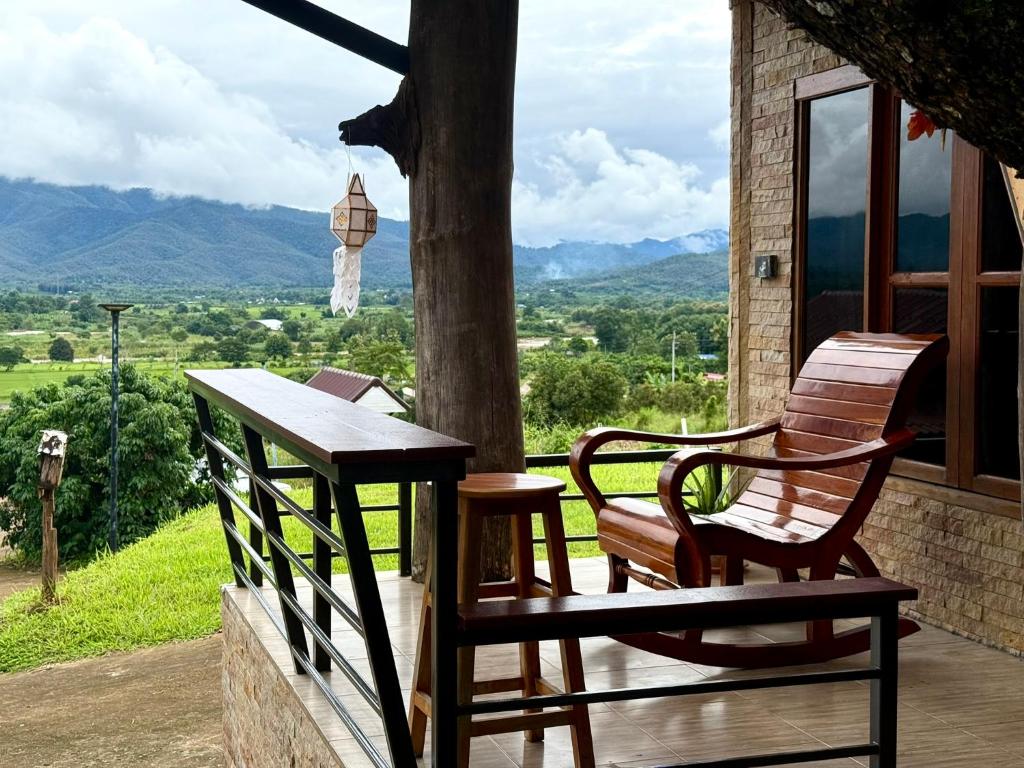 een bank en een tafel op een veranda met uitzicht bij Lanna Maple House in Ban Thap Dua