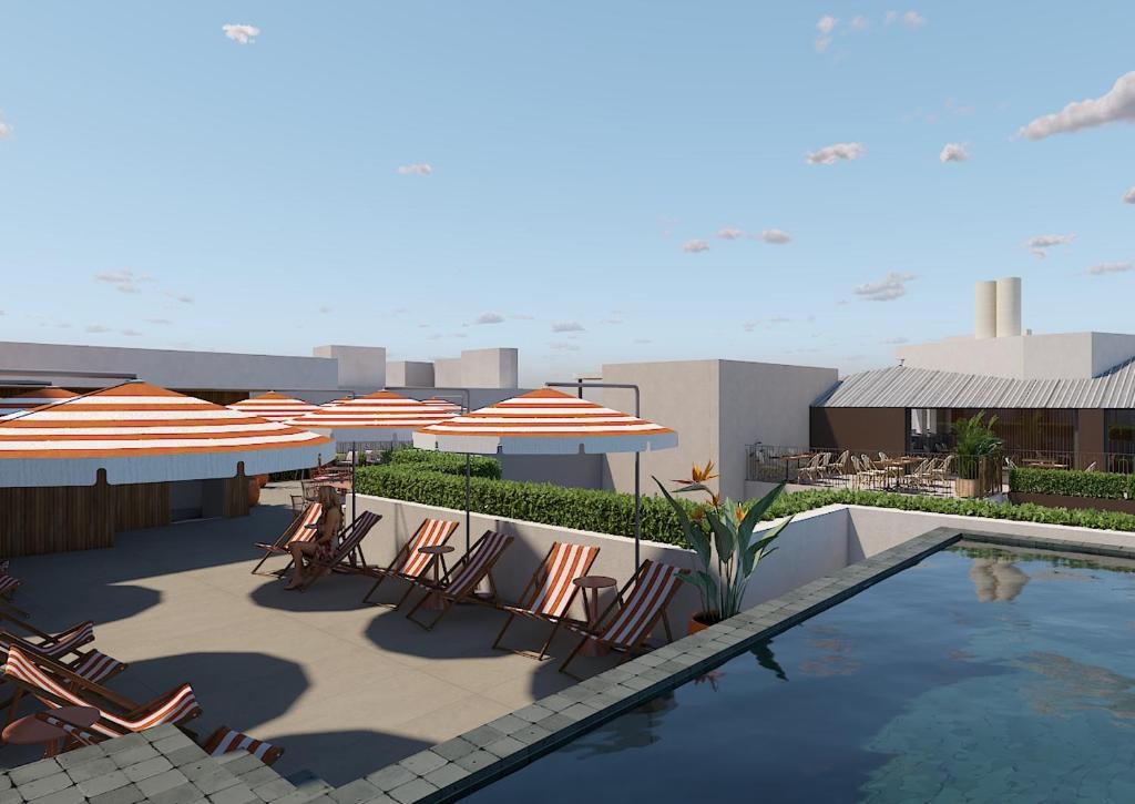 a patio with chairs and umbrellas and a swimming pool at Palacio San Juan, a Royal Hideaway Hotel in Murcia