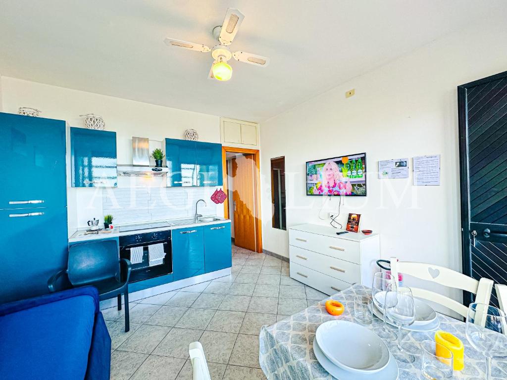 una cucina con armadi blu e tavolo da pranzo di Raffaella 3 a Campese