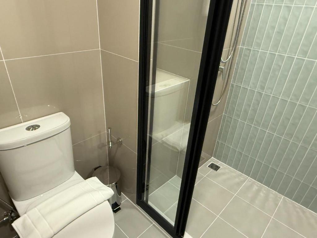 Apartment The Base Bukit Phuket في فوكيت تاون: حمام مزود بمرحاض ودش زجاجي