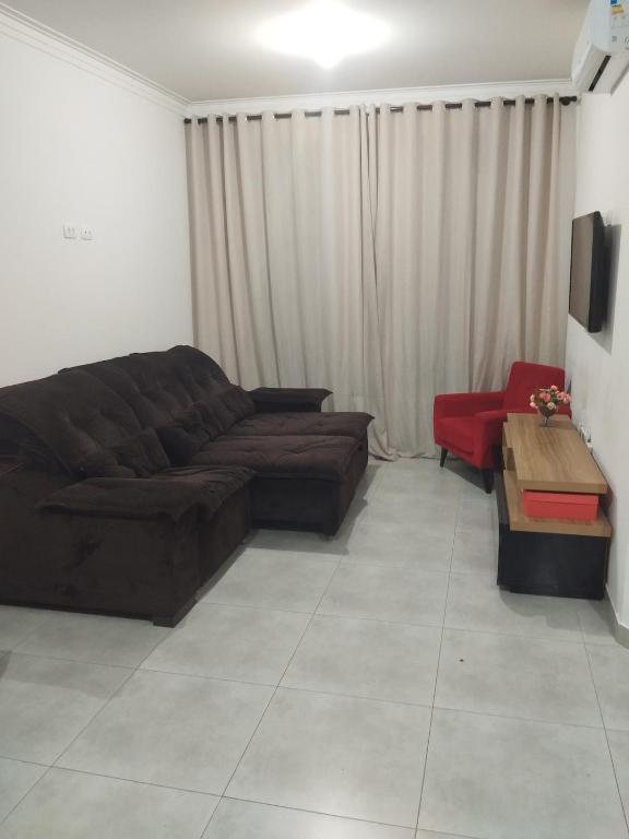 ein Wohnzimmer mit Sofa und Tisch in der Unterkunft Casa c ar condicionado à 600m mar in Itapoa