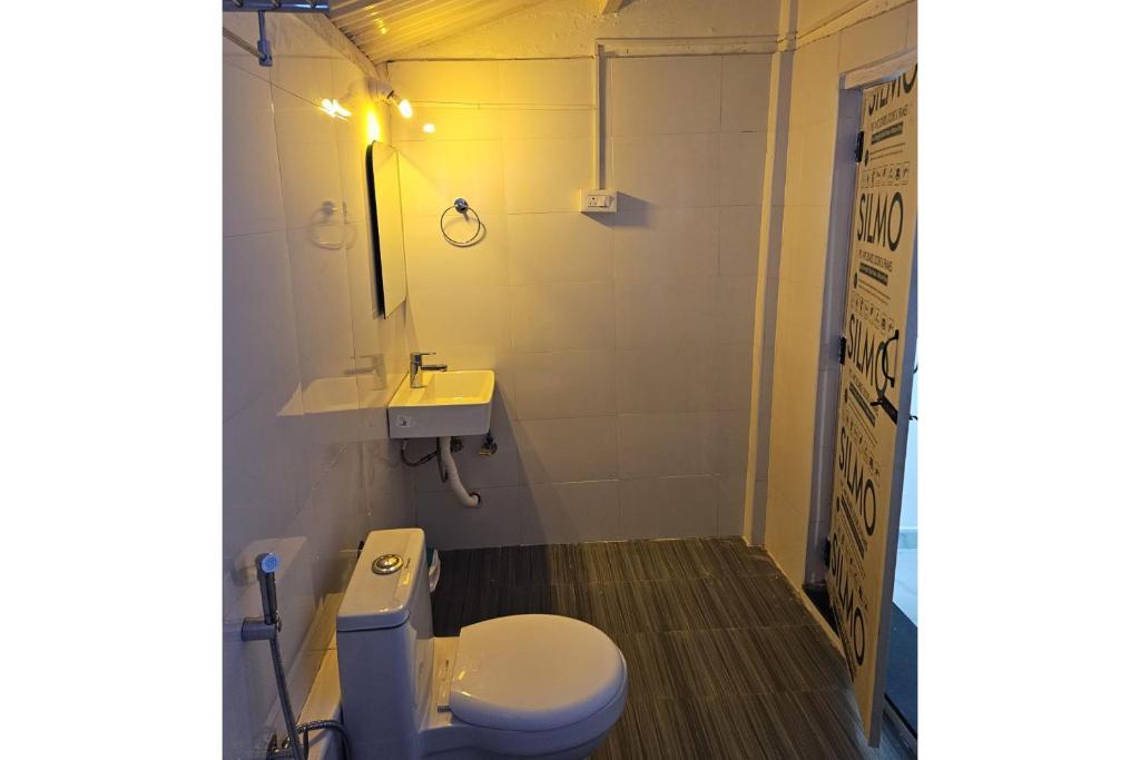 a bathroom with a toilet and a sink at Kitty Royal Inn in Ooty