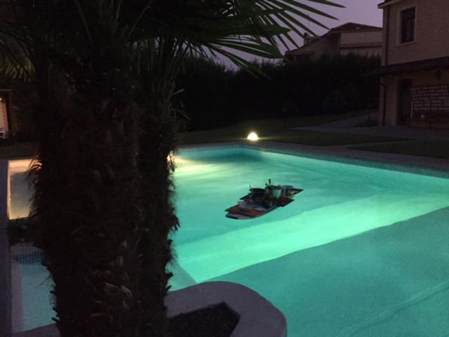 two boats sitting in a swimming pool at night at Villa 77 in Bra