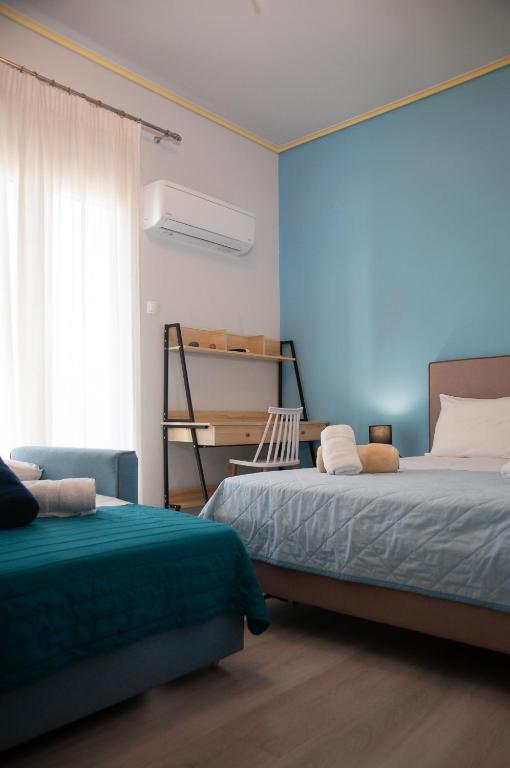 a bedroom with two beds and a blue wall at ΛΙΜΑΝΙ in Chios