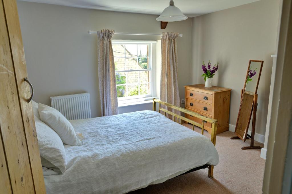 een slaapkamer met een bed, een raam en een dressoir bij Finest Retreats - Meadowsweet Cottage in Wingfield