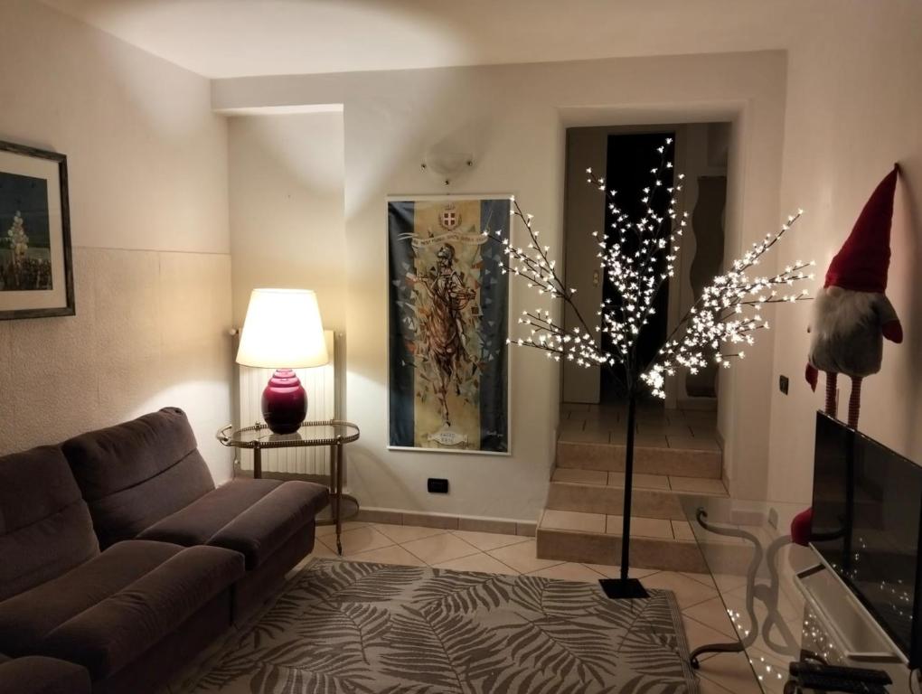 un salon avec un canapé et un sapin de Noël illuminé dans l'établissement Casa Ciuccetti, à Baldichieri