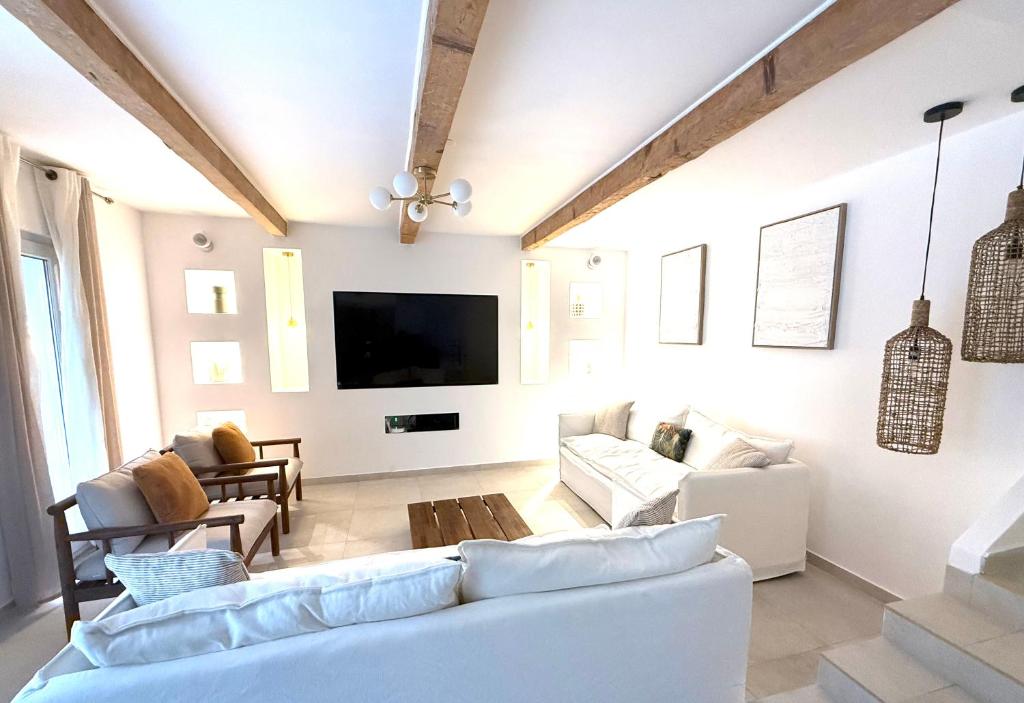 Maison Massilia Duclaux في مارسيليا: غرفة معيشة مع أثاث أبيض وتلفزيون بشاشة مسطحة