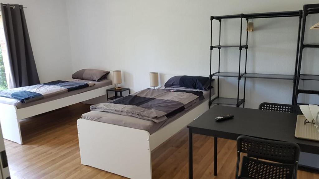 een slaapkamer met twee stapelbedden en een tafel bij Süder11 - ApartB in Eddelak